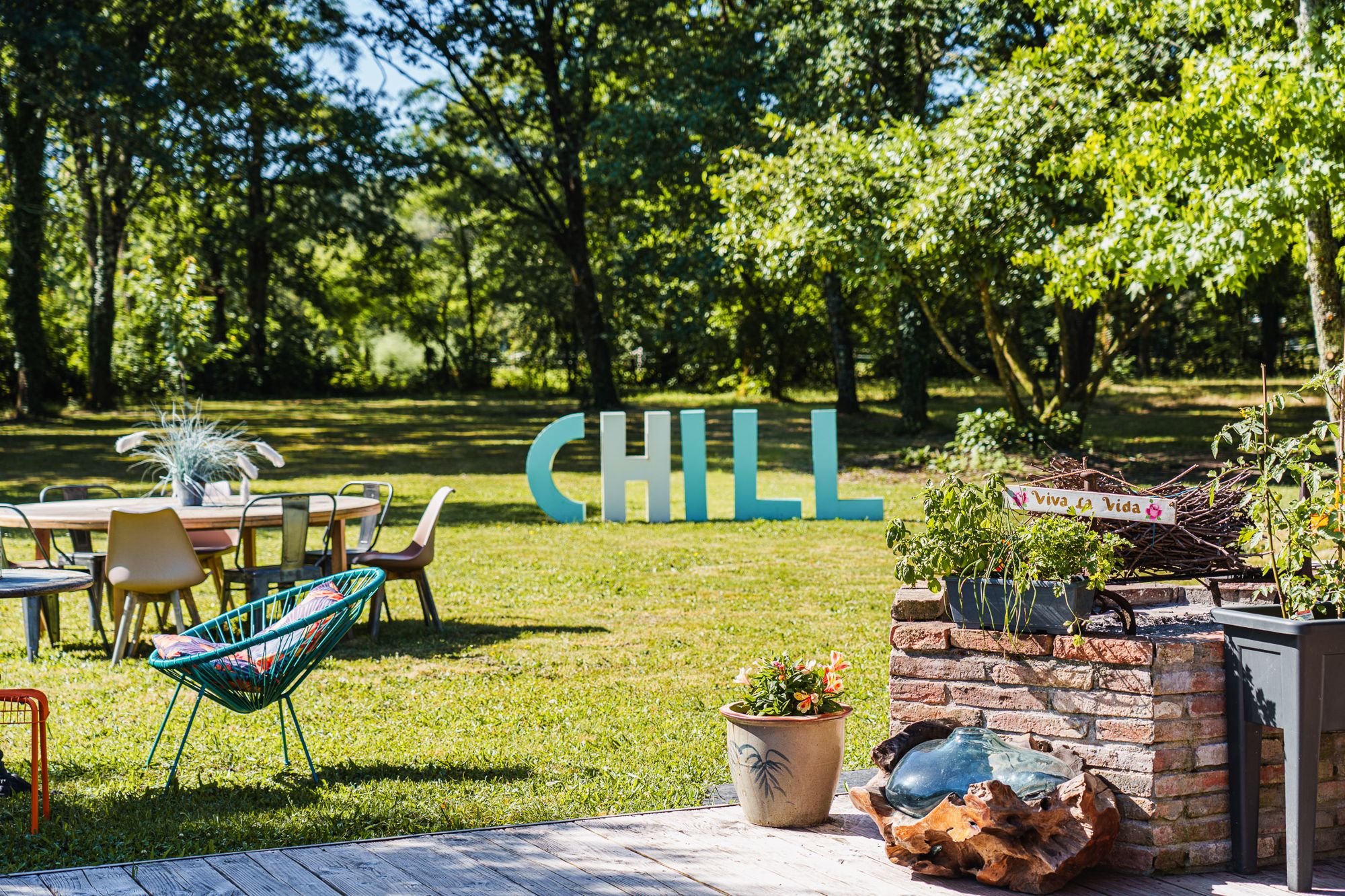 Tables et transats installés dans le parc pour une garden party, lettres CHILL